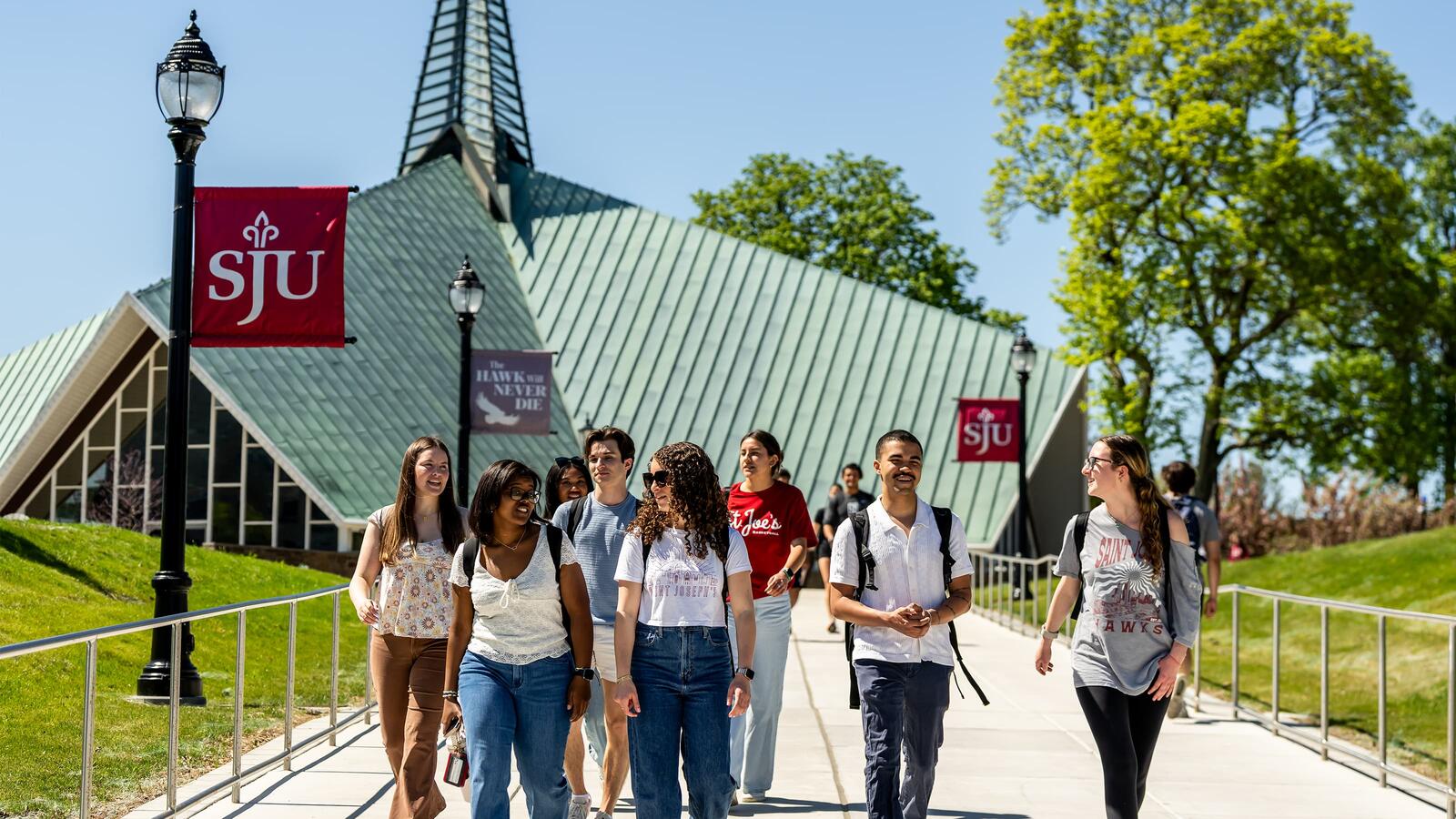 Students walking across campus in front of the Cardinal Foley Center