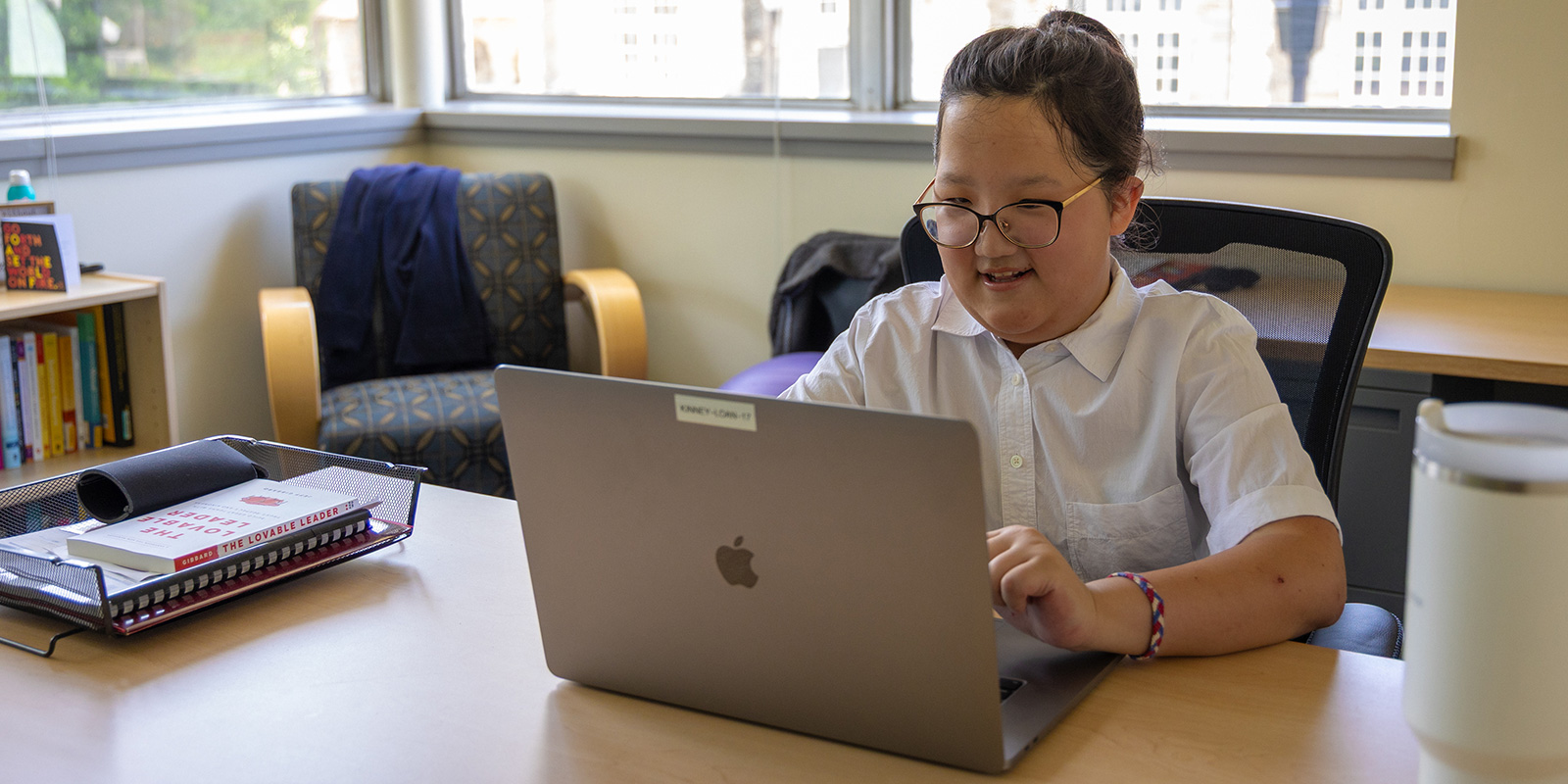 neurodivergent woman sitting at a desk in front of a laptop