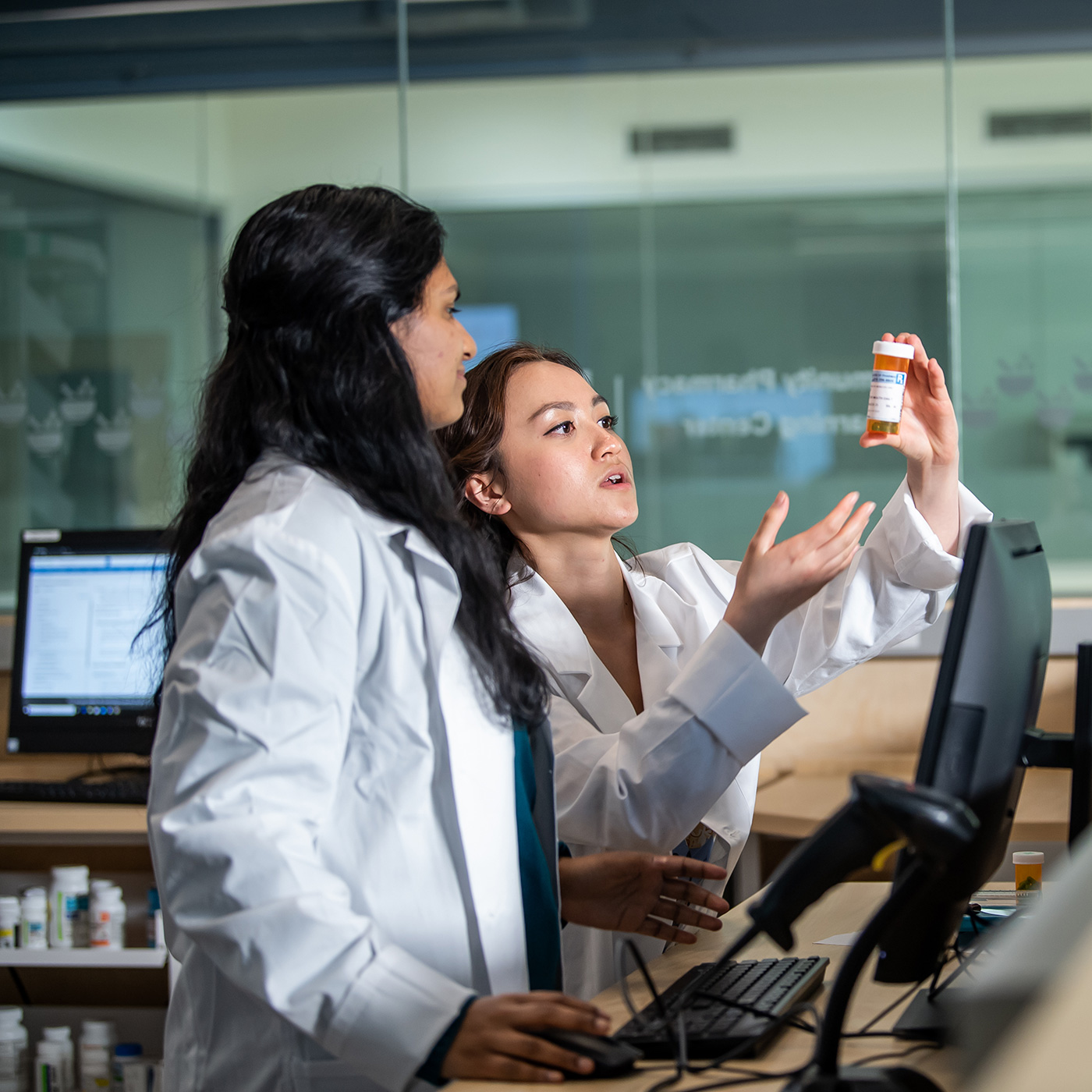 Pharmacy and business professionals in a meeting looking at computer