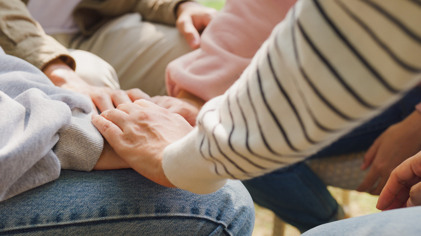 a number of hands on top of hand of someone undergoing substance abuse