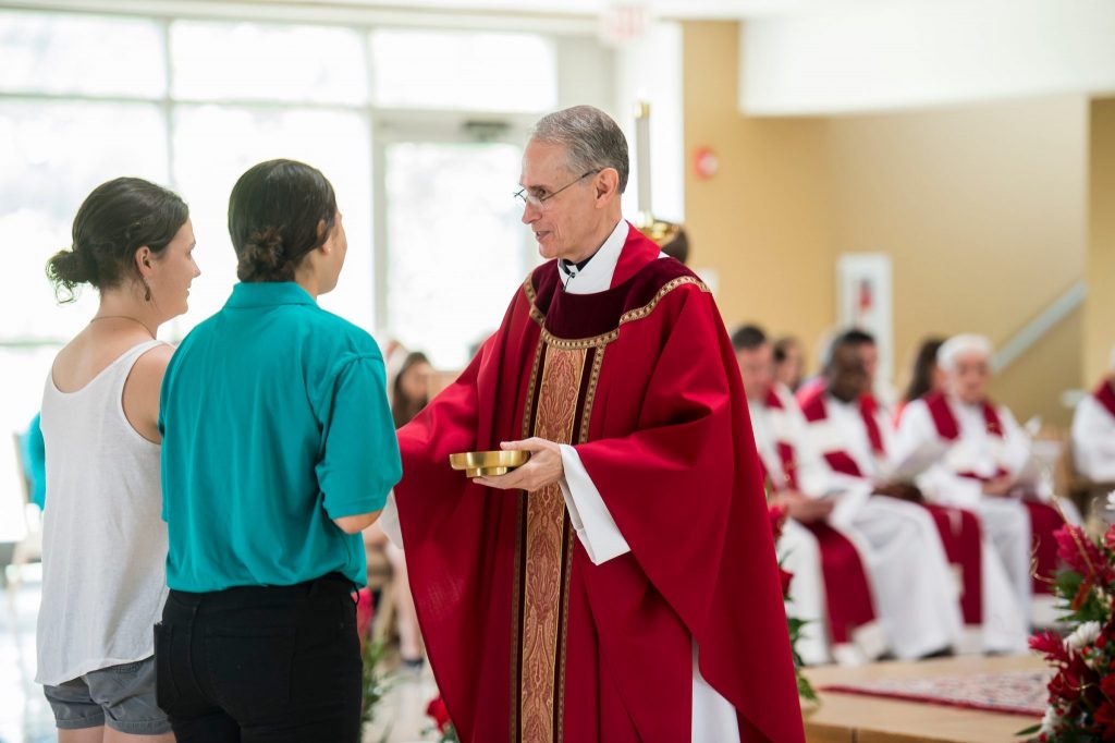 Worshippers taking communion from a priest