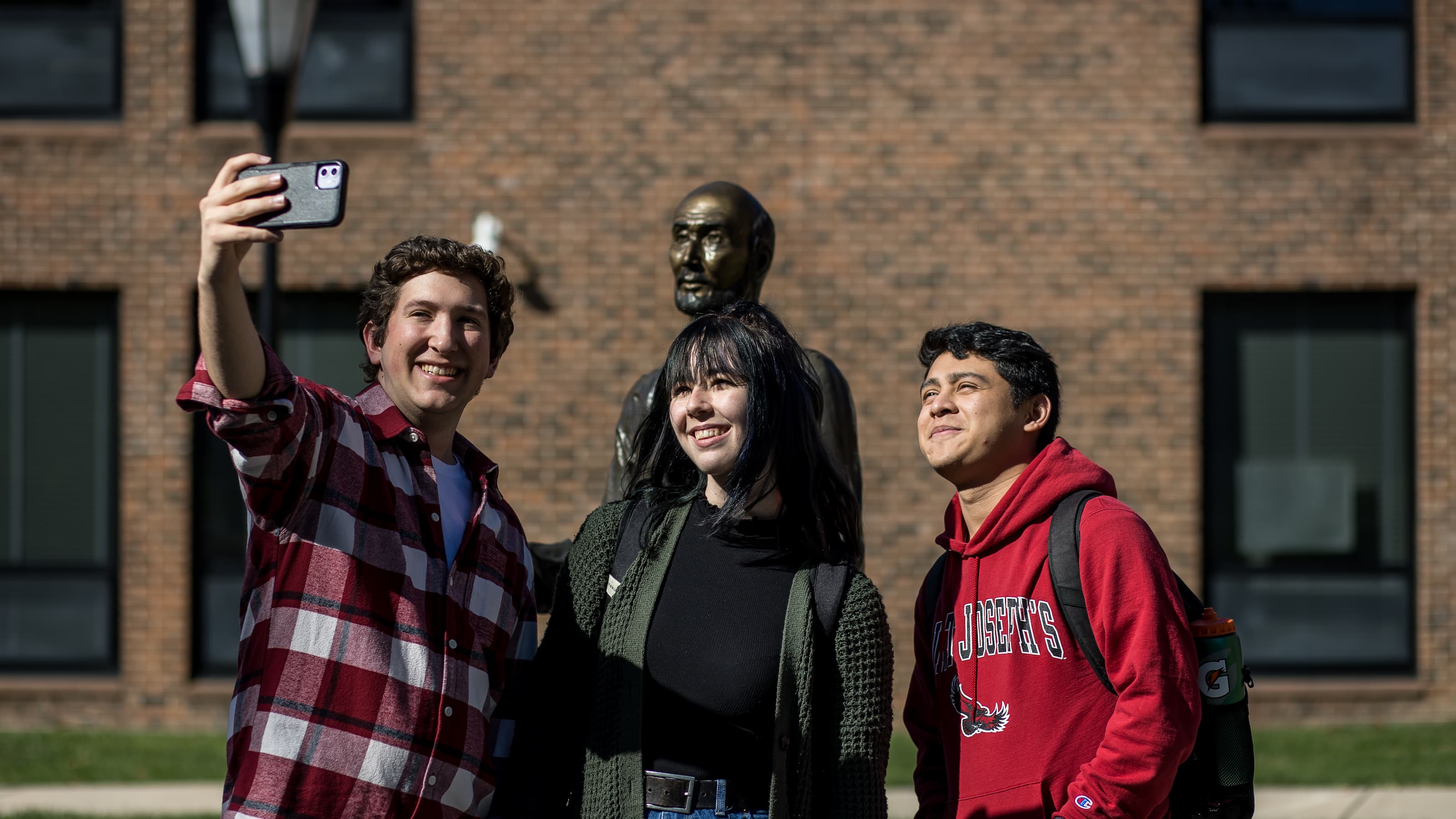 Smiling students taking a selfie outside the Perch