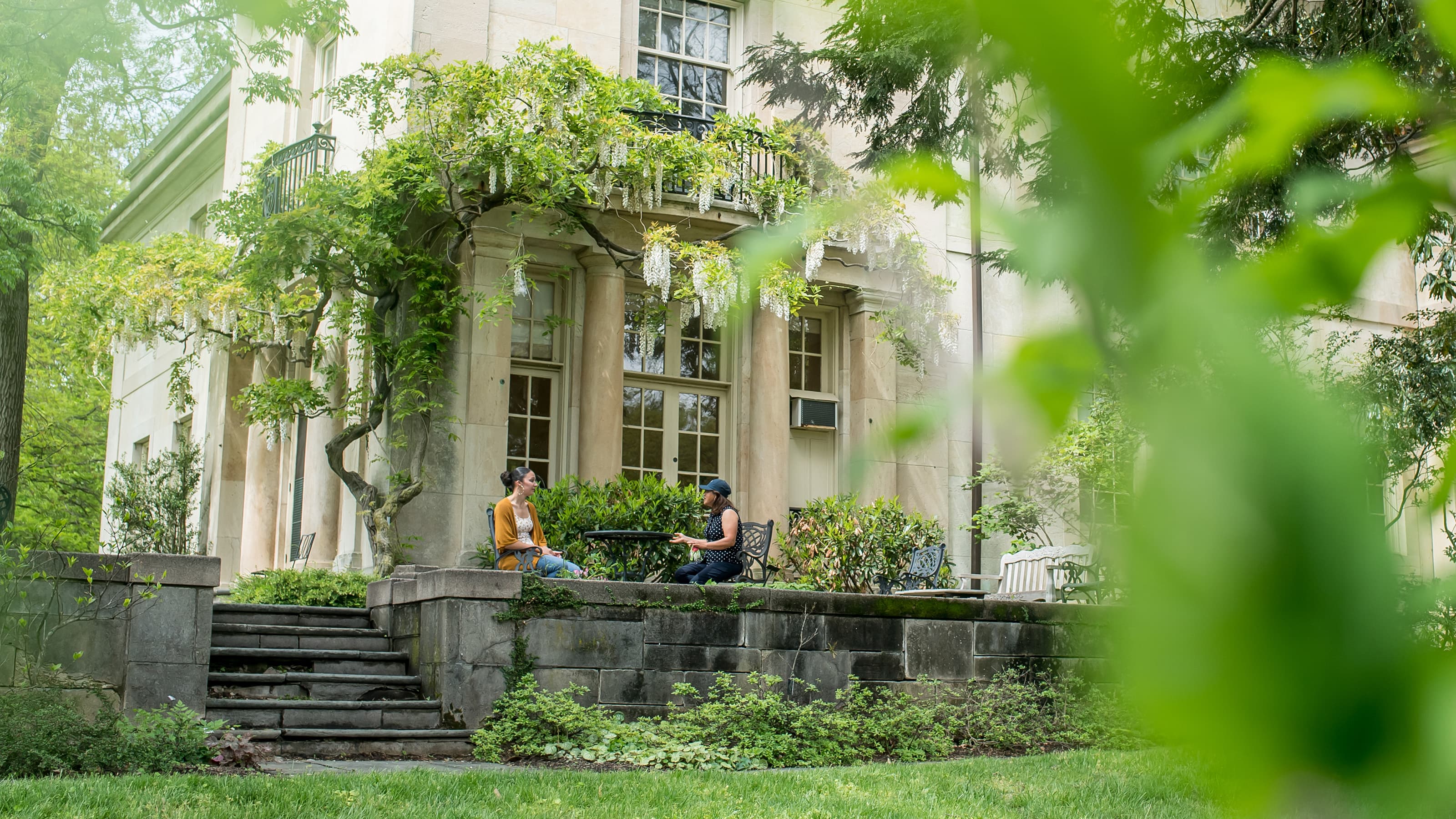 Students sitting outside the Barnes Arboretum at a table