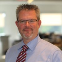 Chris Davis, man wearing a button up shirt and tie and glasses