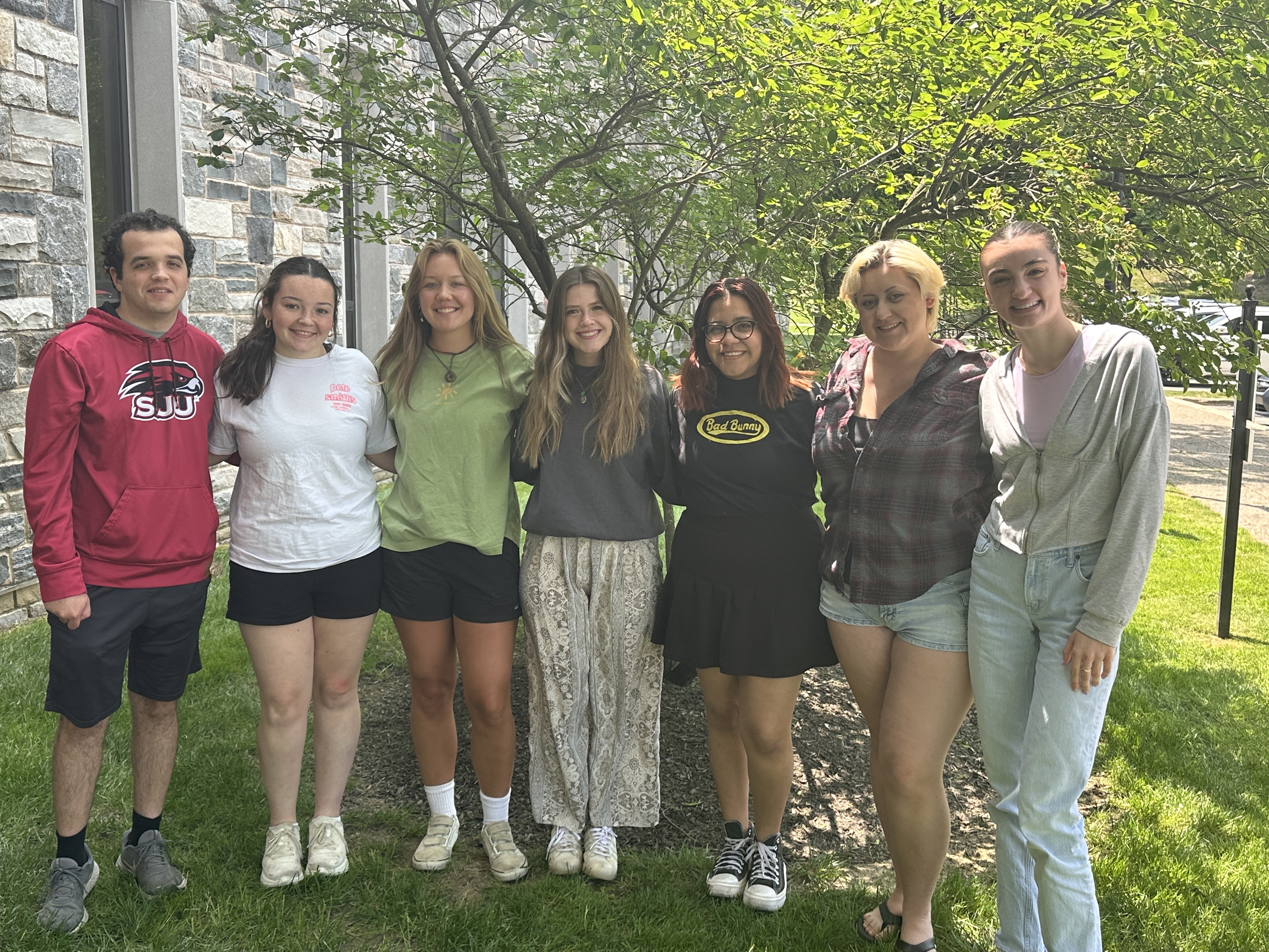 A group of students standing in a line outside