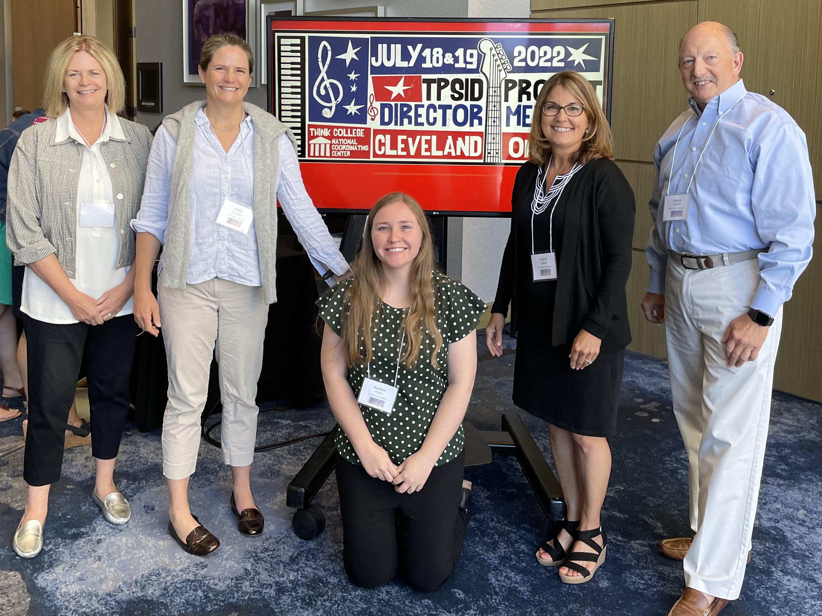 PACE Team members smiling in front of TPSID Project Director Meeting sign (From left to right: Rosemary Theveny, Dr. Mollie Sheppard, Kaitlyn Martin, Dr. Cheryl George, Dr. James Johnson)