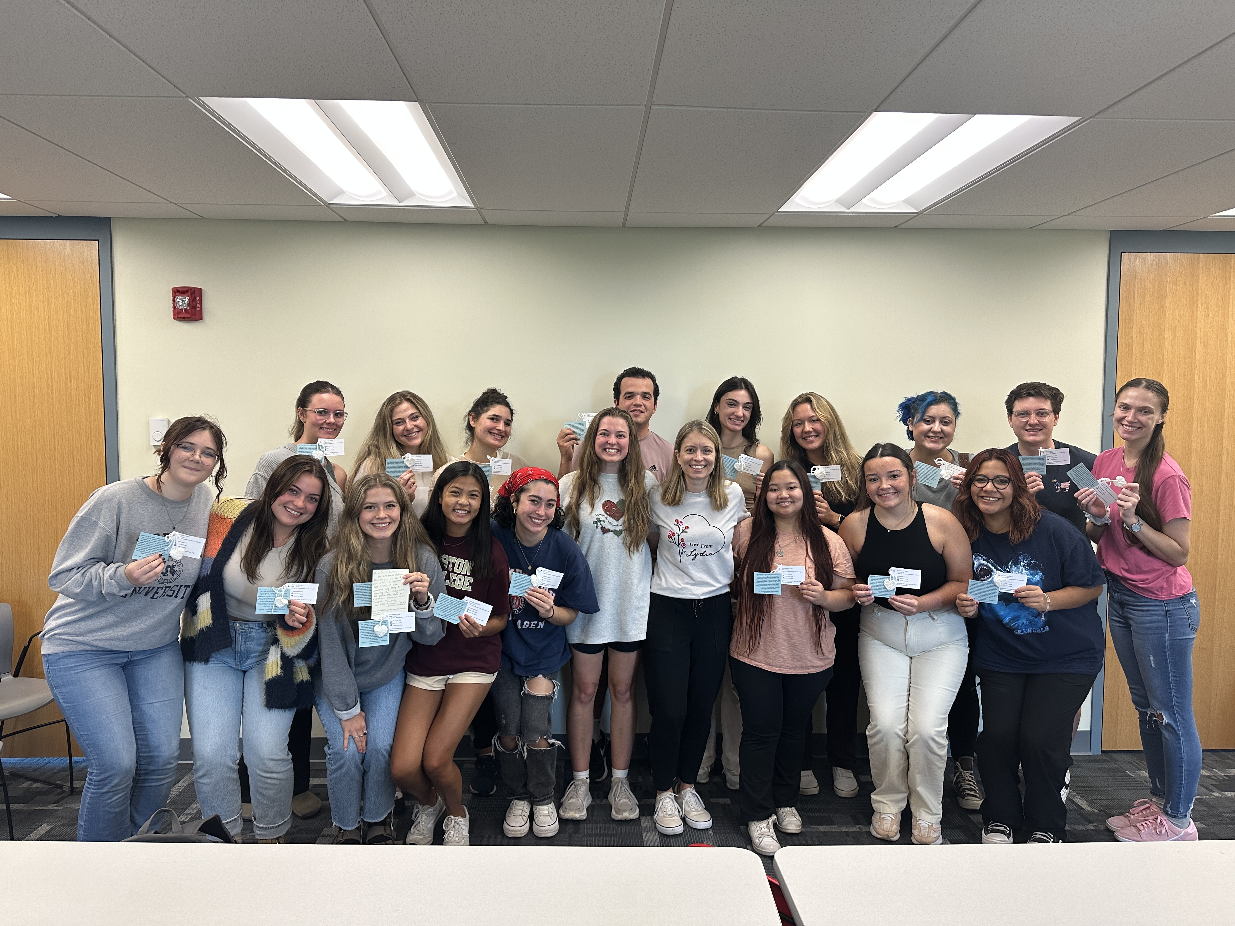 A group of students holding up knit hearts