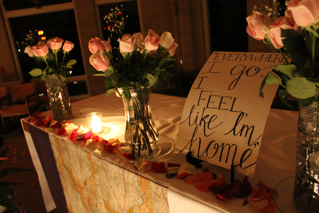 A table decorated with candles and flowers set in a dark room