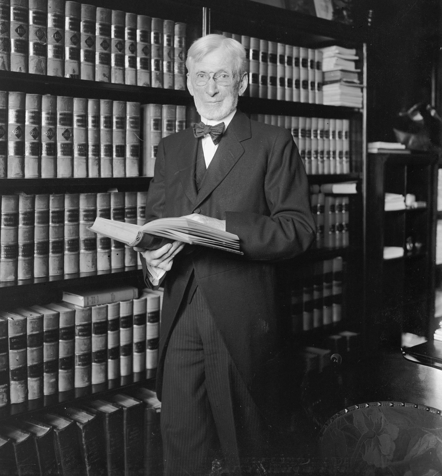 joseph mckenna standing in front of a book case