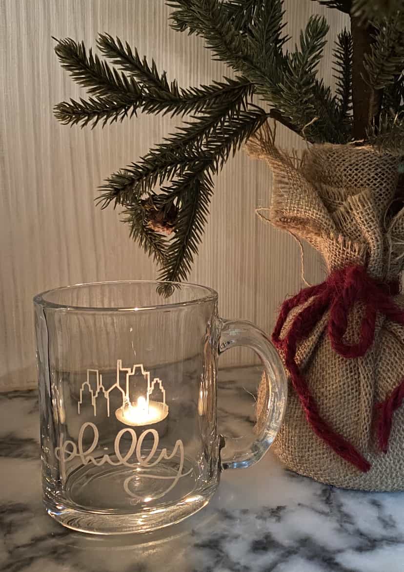 Glass mug with the word "Philly" written on it and a city skyline doodle