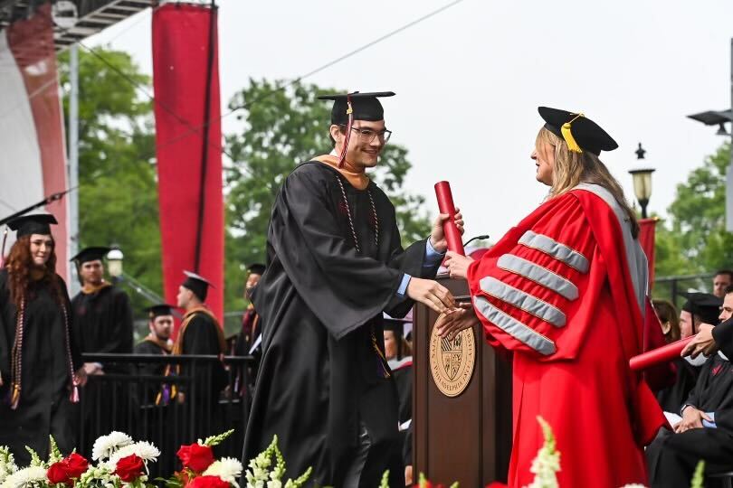 SJU Student receiving diploma from President McConnell