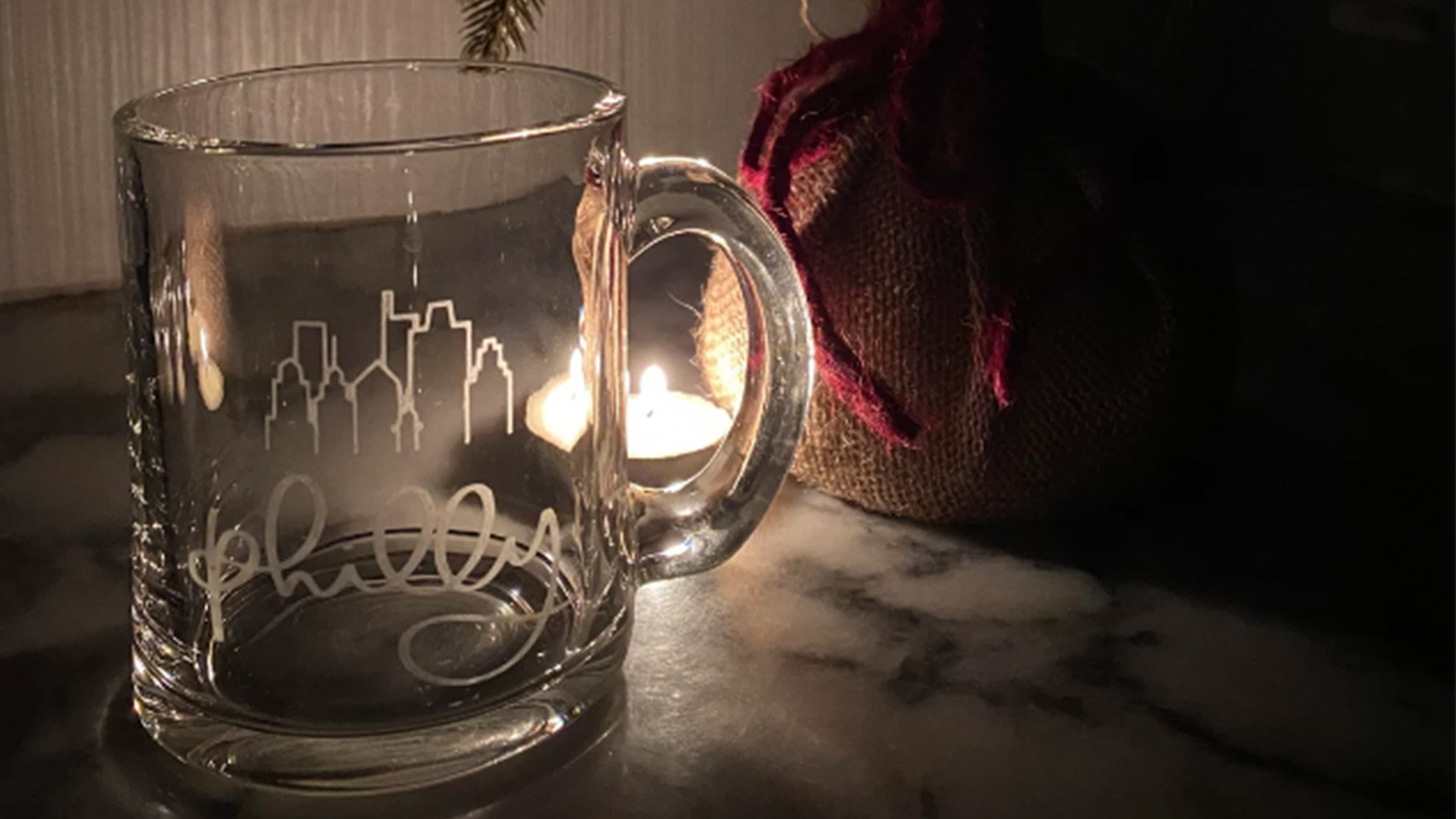 Glass Philly mug next to a small Christmas tree on a table