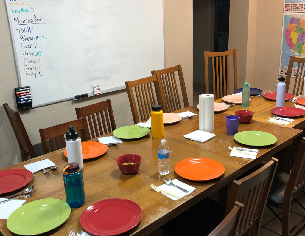 A large table with colorful plates on it set for a meal