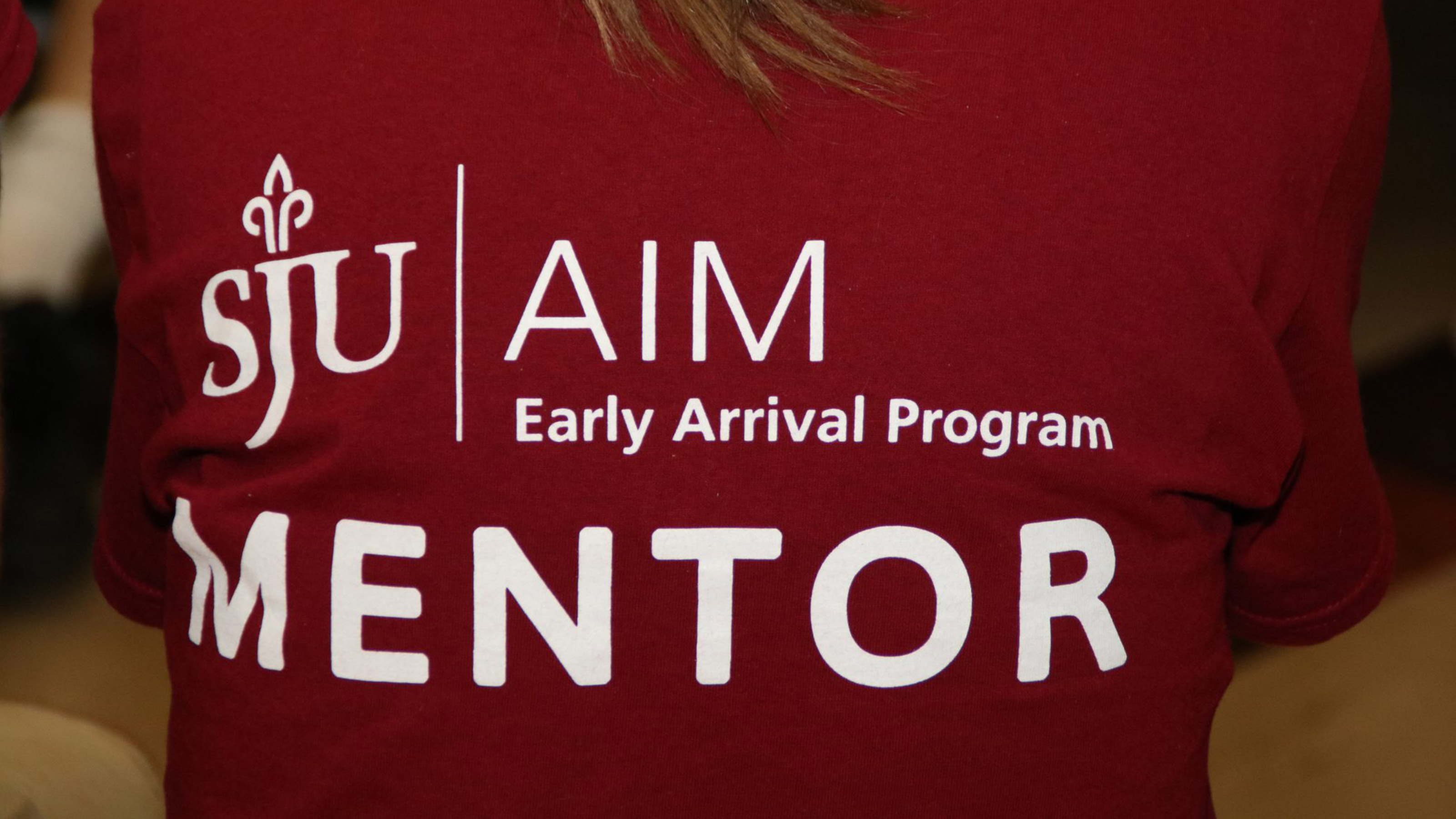 girl wearing red shirt that says AIM Early Arrival Mentor