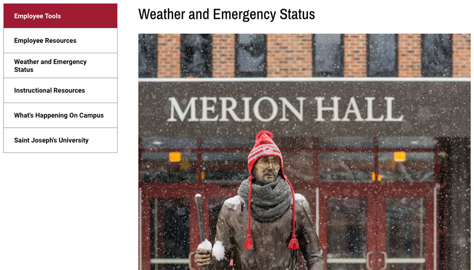 Snow falls around the university campus, the statue of Saint Joseph is covered in snow and wearing a red wool hat