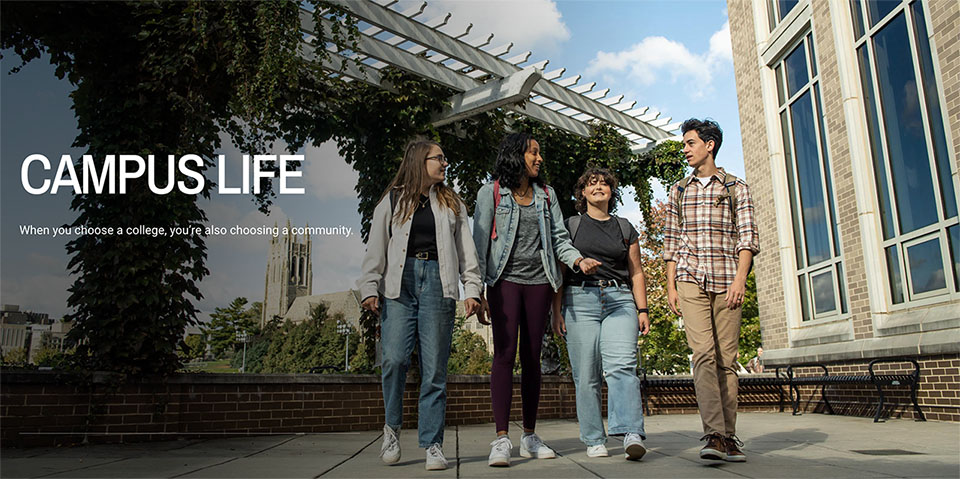 Four students walking through a paved plaza on Hawk Hill campus