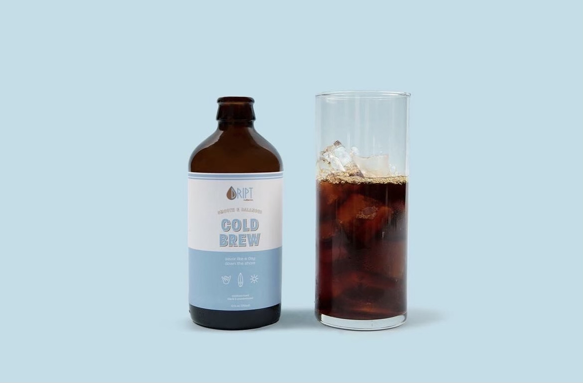 Bottle of cold brew coffee next to glass of coffee