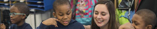 Graduate student teacher helping children
