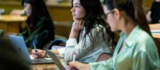 Saint Jospeh's University graduate students taking notes in class