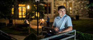 student sitting outside at night