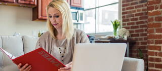 female student reading from a document in a folder