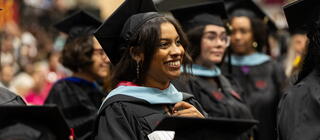 smiling female student dressed in a graduation gap and gown