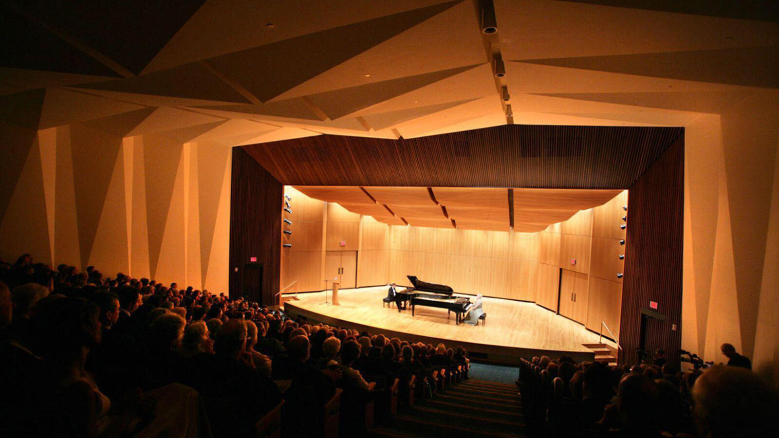 A dark concert hall with a well lit stage