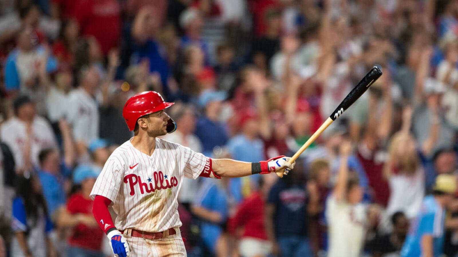 Baseball player holding a bat and looking at the crowd