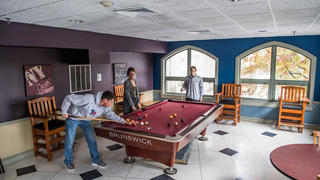 A rec room where students are playing billiards