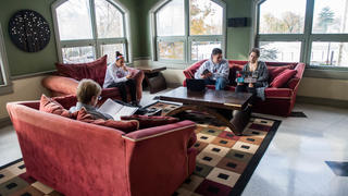 A common area with long couches and students interacting