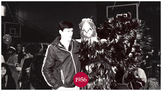 A man standing next to the Hawk mascot at Saint Joseph's University