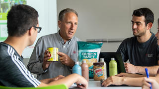 food marketing professor holding a can and pointing at a label