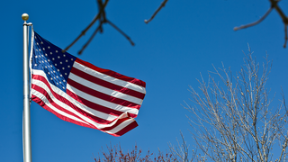 American flag with a blue sky