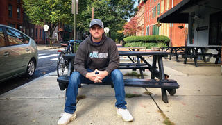 Photo of Saint Joseph's alum Noah Henderson sitting on a bench