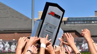 women's lacrosse team carrying a trophy
