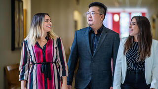 3 adults in the Human resources office talking to one another while walking