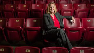 Jill Bodensteiner sitting in red stadium seats