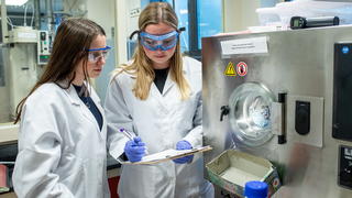 Two female students in Saint Joseph's pharmacy lab taking notes