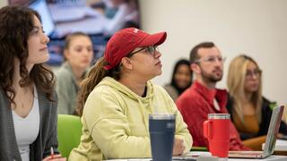 Students listening to a professor while sitting in class