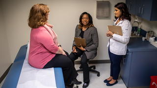 Inside PCOM patient room with patient, nurse and doctor