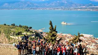 Group of students from the American College of Greece on a cliff in front of the sea