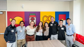 Saint Joseph's student in the new Center in front of iconography wall featuring signature Campbell's products