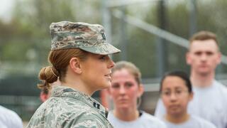 Female military cadet talking to military trainees