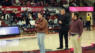 Picture at Hagan Arena of the two students singing the Alma Mater center court
