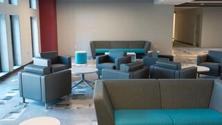Picture of a typical lounge featuring teal and gray sofas and chairs.