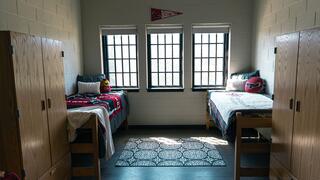 Picture of a typical student room in Sr. Thea Bowman Hall featuring two beds, two desks, and two wardrobes.