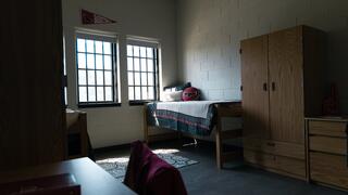 Picture of a typical student room in Sr. Thea Bowman Hall featuring two beds, two desks, and two wardrobes.