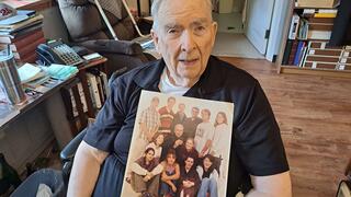 Fr. Rashford seated holding a photograph