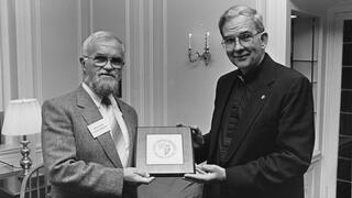 1989: Nicholas S. Rashford, S.J., with Denis Lucey of Cork College in Ireland during his visit to SJU’s campus. President Rashford is presenting Lucey with a decorative Saint Joseph’s University plaque. 
