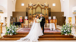 Bride and groom standing in front of altar